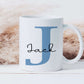 white mug with a large blue letter J printed on it with the name Jack printed in a black script font over the top