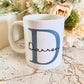 white mug with large blue letter printed with the name Darren printed over in a script font